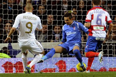 ف-Real Madrid's French forward Karim Benzema (L) scores against Granada's goalkeeper Roberto Fern&aacute;ndez