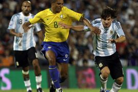 epa01850025 Argentinian soccer team player Lionel Messi (R) fights for the ball with Gilberto Silva (