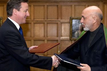 British Prime Minister David Cameron (L) and President Hamid Karzai of Afghanistan shake hands after signing an agreement which aims to achieve the goal set in 2010 of establishing a new framework for the relationship between Britain and Afghanistan at the Prime Minister's country residence of Chequers, west of London, on January 28, 2012. AFP PHOTO / CARL COURTAFP PHOTO / CARL COURT