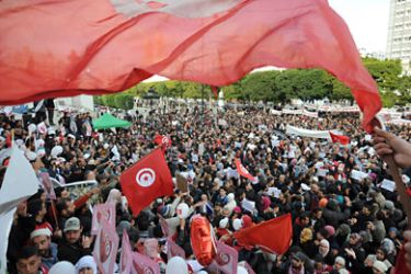 Tunis, -, TUNISIA : Hundreds of Tunisians turn out to demand jobs and dignity as the north African country marks a year to the day since its despot Zine El Abidine Ben Ali fled into exile on January 14, 2012 on Habib Bourguiba Avenue in Tunis. Some demonstrators, wearing the red and white of the national flag, called for recognition of the "martyrs" killed during the weeks of unrest before Ben Ali was toppled. AFP PHOTO / FETHI BELAID
