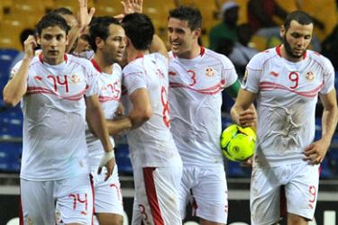ف-Tunisia national football team players celebrate with teamate Khaled Korbi (C) after he scored against Morocco
