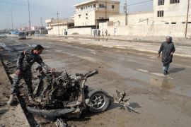 BAQUBA, -, IRAQ : An Iraqi policeman inspects the debris of a vehicle following a blast in Baquba, the provincial capital of the Diyala province, on February 23, 2012. A wave of bombings and shootings killed at least 38 people and wounded more than 250, Iraq's deadliest day in more than a month, security and medical officials said. AFP PHOTO/STR