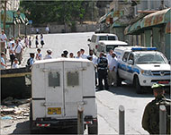 مستوطنون في حماية الشرطة والجيش الإسرائيلييْن وسط الخليل (الجزيرة نت)