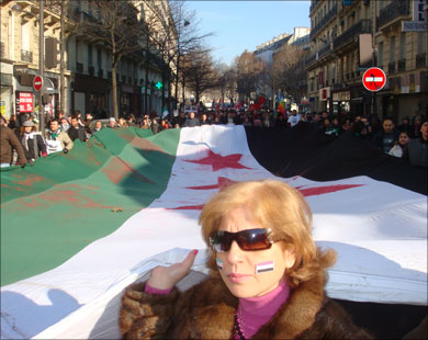 متظاهرون يحملون علم الثورة السورية في مسيرة حاشدة بباريس (الجزيرة نت) 