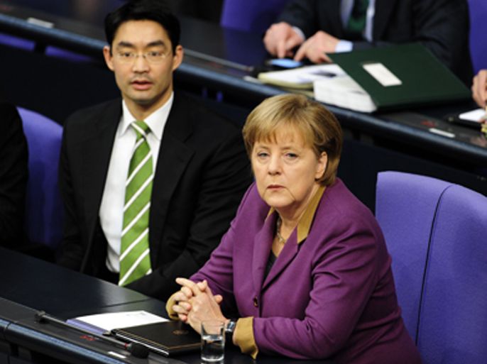 German Chancellor Angela Merkel and German Economy Minister and vice-chancellor Philipp Roesler sit on the government's bench at the Bundestag (lower house of parliament) on February 27, 2012 in Berlin. German lawmakers are set to approve a Greek rescue package despite signs the public's patience over bailing out Greece is running out. The parliament motion is expected to pass easily as the two main opposition parties, the Social Democratic Party (SPD) and Greens, have said they will vote in favour, as they did in two previous eurozone votes