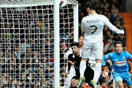 DP02 - Madrid, -, SPAIN : Real Madrid's Portuguese forward Cristiano Ronaldo (C) heads the ball and scores during the Spanish league football match Real Madrid vs Racing on February 18, 2012 at the Santiago Bernabeu stadium in Madrid. AFP PHOTO