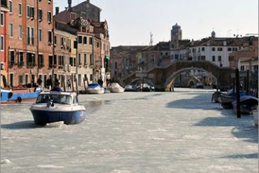 A small boat passes on a canal covered with ice on February 6, 2012 in Venice. Temperatures fell to minus 10 degrees Celsius (14 degrees Fahrenheit) in Milan on Monday as 59,000 households remained without electricity in Italy and officials declared a gas supply emergency. AFP PHOTO / Marco Sabadin