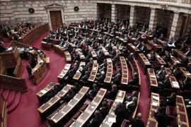 Greek Prime minister Lucas Papademos (L) addresses lawmakers during a crucial vote in the parliament, in Athens, late on February 12, 2012.
