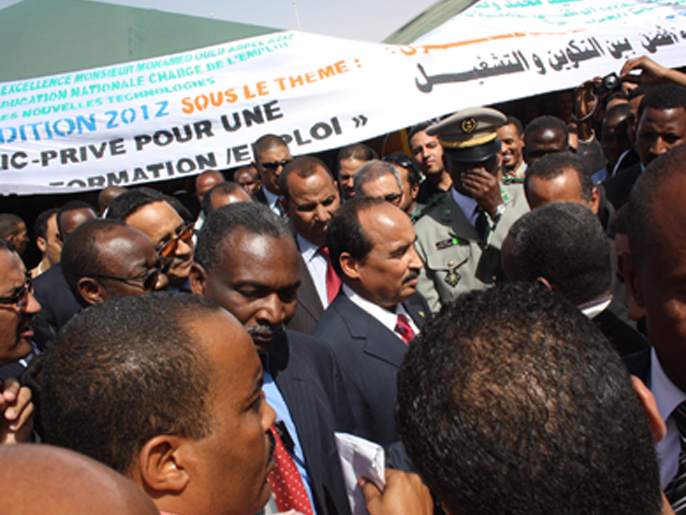 الرئيس الموريتاني يتوسط مجموعة من الشباب العاطلين خلال المعرض (الجزيرة نت)