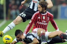 epa03121900 Juventus' Arturo Vidal (bottom) vies for the ball with Milan's Luca Antonini (C) during the Italian Serie A soccer match between AC Milan and Juventus FC at the Giuseppe Meazza stadium in Milan