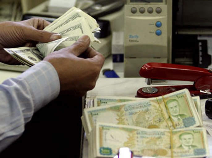 A Syrian bank worker counts US dollar bills at a bank in Damascus 21 September 2005. The Syrian government has taken a series of measures to attempt to curb the black market on the dollar and support the Syrian pound as part of its economic reforms at the time when the country faces strong international pressures. AFP PHOTO/LOUAI BESHARA