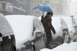 A man walks past snow covered cars in central Belgrade on February 3, 2012. Temperatures plunged to new lows in Europe where a week-long cold snap has now claimed more than 220 lives and forecasters warned that the big freeze would tighten its grip at the weekend. AFP PHOTO / ANDREJ ISAKOVIC