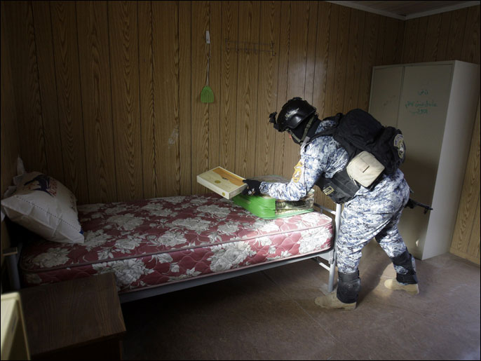 ‪(الفرنسية-أرشيف)‬ جندي عراقي يفتش غرفة داخل بيت في معسكر أشرف