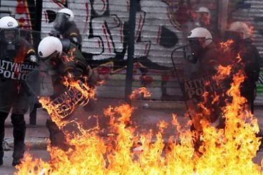 petrol bomb explodes at riot police during a 48-hour general strike in Athens on February 10, 2012. Greek protesters threw stones and firebombs at riot police who responded with tear gas in Athens on February 10 as clashes erupted on the sidelines of a protest against new austerity cuts.