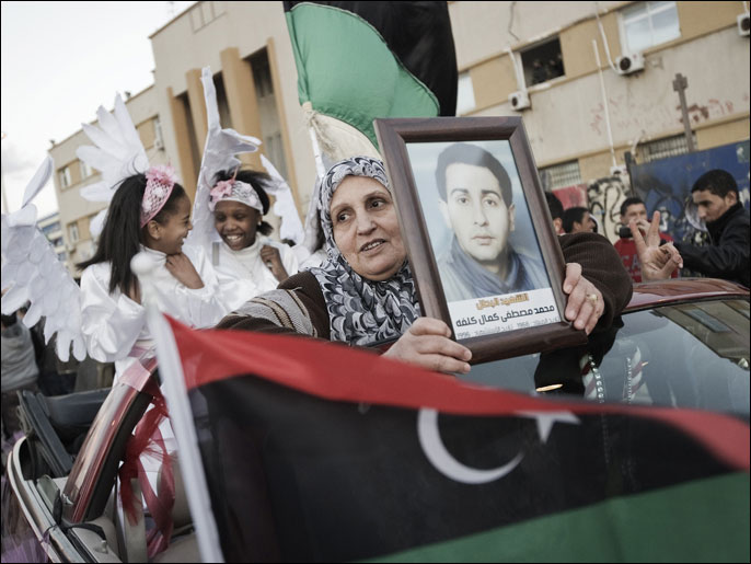 
امرأة تحمل أمس في بنغازي صورة قريب لها قتل في الثورة (الفرنسية)
