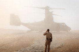 US Marine watches as an Osprey carrying United States Secretary of Defense Leon Panetta arrives March 14, 2012 at Forward Operating Base Shukvani, Afghanistan
