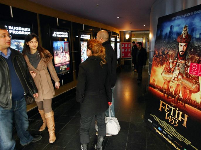 Turkish filmgoers are pictured next to a poster of "Fetih 1453" or "Conquest 1453", depicting the conquest of Istanbul by Ottoman Turks at a cinema in Ankara on February 27, 2012. Since it was first screened on February 16 at a symbolic time of 14:53, some 2.5 million viewers have watched the film, according to Box Office Turkey statistics.