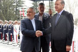 Iran's First Vice President Mohammad Reza Rahimi (L) shakes hands with Turkish Prime Minister Recep Tayyip Erdogan during a welcoming ceremony under the rain in Tehran on March 28, 2012. AFP PHOTO/ATTA KENARE