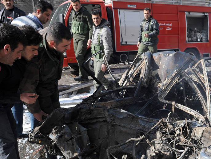 ‪مواطنون يتفقدون سيارة دمرت بمكان الانفجار‬ مواطنون يتفقدون سيارة دمرت بمكان الانفجار (الفرنسية)