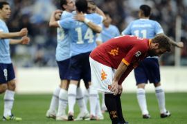 AS Roma's midfielder Daniele De Rossi (C) reacts as Lazio's players celebrate their victory 2-1 after an Italian Serie A football match in Rome's Olympic Stadium on March 4, 2012. AFP PHOTO / Filippo MONTEFORTE