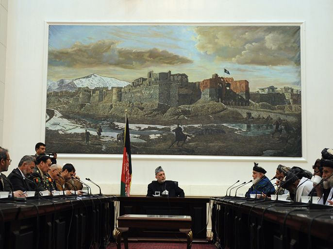 Afghan President Hamid Karzai listens to an elder speaking during a meeting with relatives of the Kandahar incident victims at the Presidential Palace in Kabul on March 16, 2012. President Hamid Karzai on March 16, accused the US of failing to cooperate over an investigation into the massacre of 16 Afghan villagers blamed on a lone US army sniper.