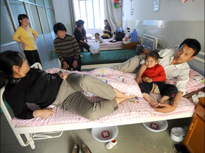 afp : Chinese parents accompany their children who are undergoing treatment at a hospital in Fuyang city, eastern China's Anhui province on April 29, 2008, where children were taken in with fever, blisters, mouth ulcers or rashes on the hands and feet, all symptoms of the virus known as enterovirus 71, or EV71. Chinese press reported that the local authorities in eastern China tried to cover up an outbreak of a highly contagious virus that has killed 20 children and left more than 1,500 others ill. CHINA OUT GETTY OUT AFP PHOTO