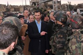 A handout picture releasd by the official Syrian news agency SANA shows President Bashar al-Assad (C) addressing soldiers during his visit to the Baba Amr neighbourhood in the restive city of Homs on March 27, 2012. Assad toured the former rebel stronghold, assuring residents that the