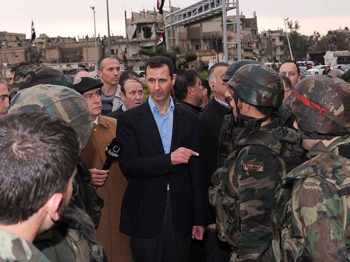 A handout picture releasd by the official Syrian news agency SANA shows President Bashar al-Assad (C) addressing soldiers during his visit to the Baba Amr neighbourhood in the restive city of Homs on March 27, 2012. Assad toured the former rebel stronghold, assuring residents that the