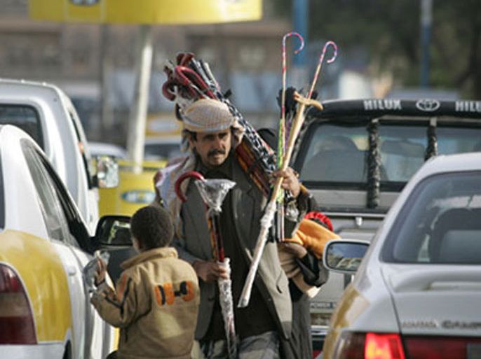 A child begs for money from cars at a traffic light stop in Sanaa February 25, 2008. Thousands of children, mostly boys are trafficked from impoverished Yemeni villages to Saudi Arabia and other rich Gulf countries to work illegally as beggars, camel jockeys,