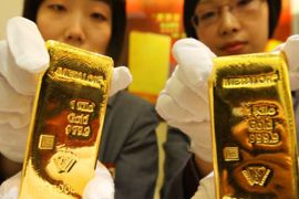 epa02091575 A photograph made available on 25 March 2010 showing two salesgirls show the one kilo Metalor gold bullions made by Swiss company Metalor on the first day of trading in Beijing 24 March 2010. It is the first foreign brand gold bullion traded in Beijing. EPA/LAO CAI CHINA OUT