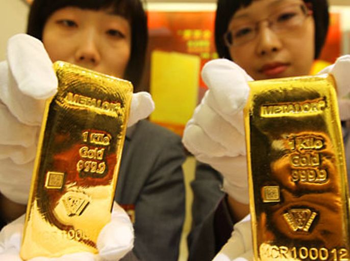 epa02091575 A photograph made available on 25 March 2010 showing two salesgirls show the one kilo Metalor gold bullions made by Swiss company Metalor on the first day of trading in Beijing 24 March 2010. It is the first foreign brand gold bullion traded in Beijing. EPA/LAO CAI CHINA OUT