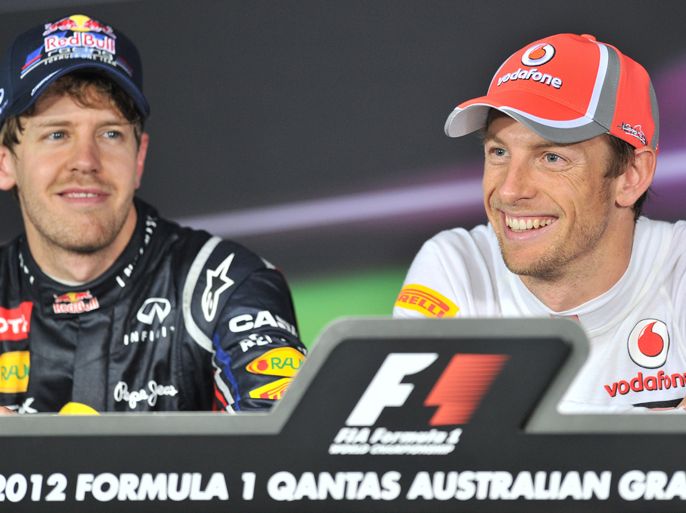 McLaren-Mercedes driver Jenson Button (R) of Britain smiles broadly as second-placed Sebastian Vettel of Germany (L) looks on at the post race press conference for Formula One's Australian Grand Prix in Melbourne on March 18, 2012. Button led throughout the opening race of the 2012 Formula One Grand Prix on the 5.3km Albert Park road circuit.