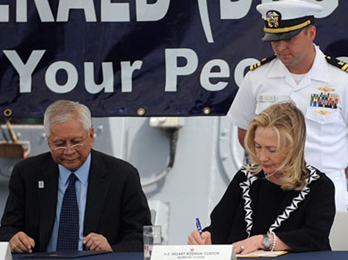 us secretary of state hillary clinton (r), beside philippine foreign affairs secretary alberto del rosario (l), signs a declaration marking the 60 years since the united states signed a security treaty with the philippines on board the uss fitzgerald, a us navy destroyer, docked at the manila bay on november 16, 2011. (الفرنسية)