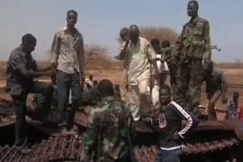 An image grab taken from footage obtained by AFP shows Sudanese troops and civilian youths standing on the remains of a destroyed tank on March 29, 2012, one day after recapturing Sudan's southern oil centre of Heglig following fighting with South Sudanese forces along the border. Southern troops had taken the Heglig oil field, parts of which are claimed by both countries, but Sudanese forces later retook the field as both sides vowed to step back from the brink of all out war after three days of border violence including airstrikes and tank battles.