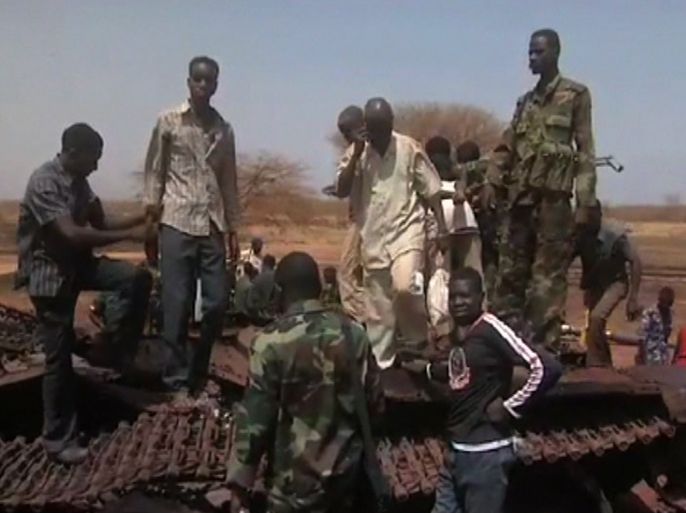 An image grab taken from footage obtained by AFP shows Sudanese troops and civilian youths standing on the remains of a destroyed tank on March 29, 2012, one day after recapturing Sudan's southern oil centre of Heglig following fighting with South Sudanese forces along the border. Southern troops had taken the Heglig oil field, parts of which are claimed by both countries, but Sudanese forces later retook the field as both sides vowed to step back from the brink of all out war after three days of border violence including airstrikes and tank battles.