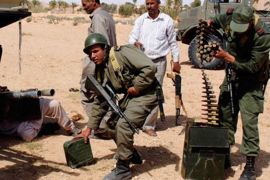 tunisian army soldiers pick up ammunition from an overturned car which belongs to forces loyal to libyan leader muammar gaddafi after clashes with tunisians and rebel fighters in dehiba near the libyan and tunisian border crossing of dehiba april 29, 2011. (رويترز)