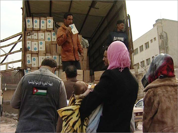اللاجئون السوريون بالأردن يتلقون المساعدات (الجزيرة نت)