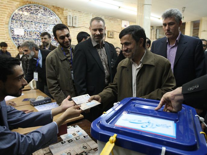 Iranian President Mahmoud Ahmadinejad (C) presents his certification card before voting at a polling station in Tehran on March 2, 2012. Iran voted for a new parliament in the first nationwide elections since a bitterly contested 2009 poll that returned Ahmadinejad to power, posing a new test of his support among conservatives.