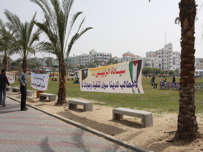 المحرر المريض رائد درابيه قرب اللافتات التي تطالب الرئيس الفلسطيني بإنصاف المحررين  (الجزيرة نت)