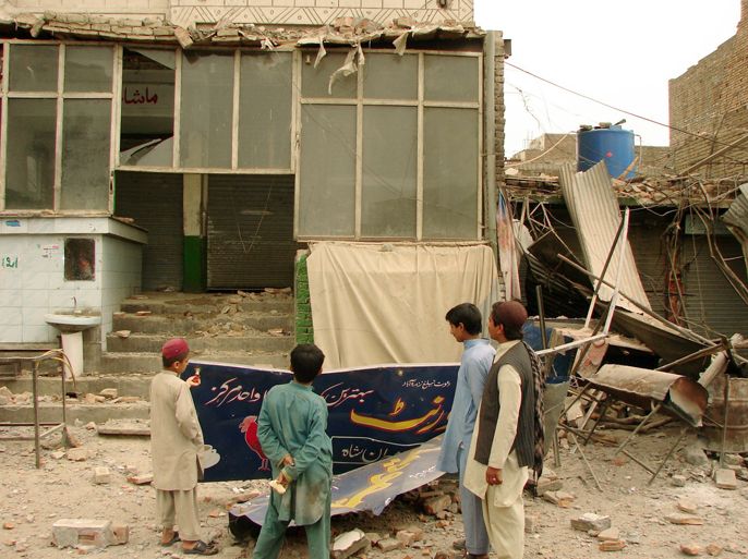 Pakistani youths look at a destroyed shop near Miranshah on March 19, 2012, after clashes between Pakistani troops and militants. At least eight people were killed and 15 others wounded in clashes between Pakistani troops and militants in the restive northwestern tribal belt, officials said.