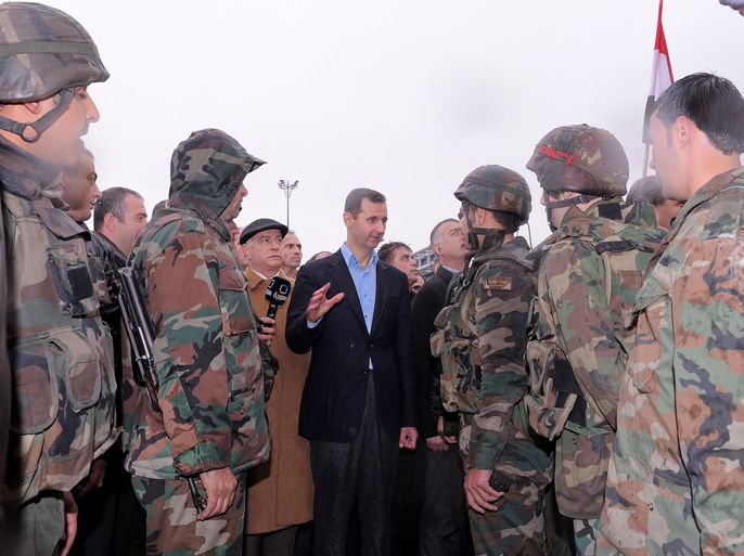 A handout picture releasd by the official Syrian news agency SANA shows President Bashar al-Assad (C) addressing soldiers during his visit to the Baba Amr neighbourhood in the restive city of Homs on March 27, 2012. Assad toured the former rebel stronghold, assuring residents that the battered neighbourhood would be rebuilt and that normal life would resume.