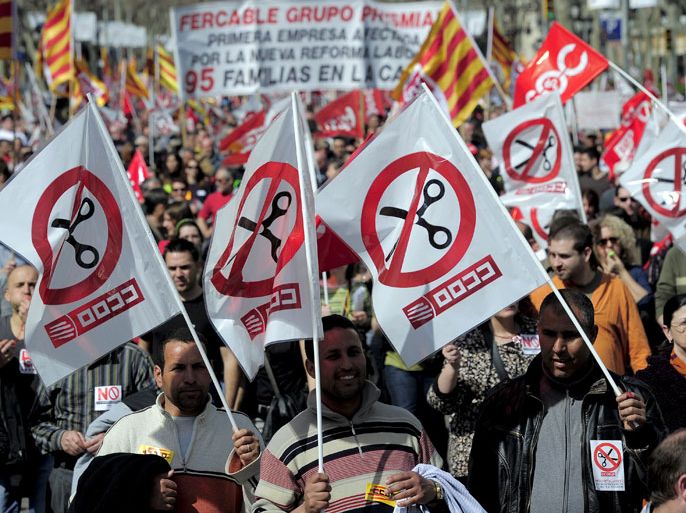 : People, some waving flags of the CCOO union, take part in a protest march against the government new labour reform in Barcelona on March 11, 2012. Unions hold anti-austerity demonstrations in about 60 towns across Spain, a test of support for a general strike called for March 29. AFP PHOTO / JOSEP LAGO