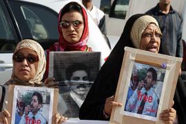 f: bahraini women holding pictures of human rights activist abdul hadi al-khawaja take part 21 november 2004 in a protest in front of a manama court during the trial of al-khawaja, (الفرنسية)