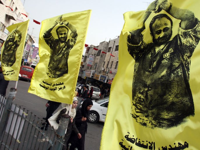 Flags covered with pictures of jailed Fatah leader Marwan Barghuti and text reading in Arabic "the engineer of the Intifadah (uprising) and the symbol of national unity"