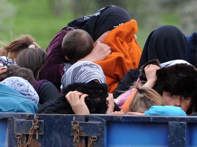 Syrian refugees hide their face as they arrive near the border between Syria and Turkey at Reyhanli in Antakya on March 15, 2012. Some 1,000 Syrian refugees, including a defecting general, crossed into Turkey in 24 hours