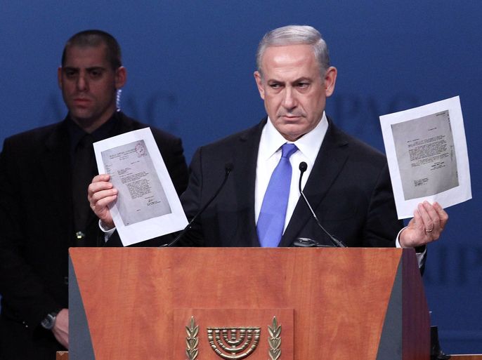 Israeli Prime Minister Benjamin Netanyahu holds documents from World War Two regarding the possible bombing of the concentration camp in Auschwitz while speaking to the American Israel Public Affairs Committee (AIPAC) at their annual conference in Washington DC, March 5, 2012.