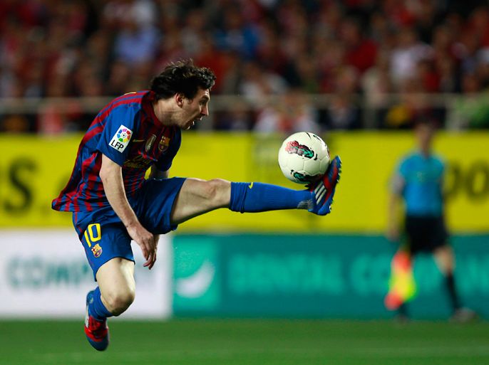 Barcelona's Lionel Messi jumps as he controls the ball during their Spanish First Division soccer match against Sevilla at Ramon Sanchez Pizjuan stadium in Seville March 17, 2012.