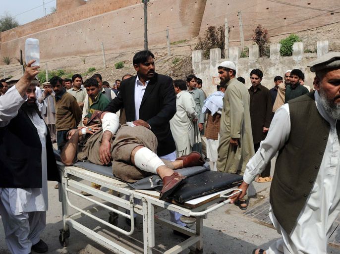 Relatives shift an injured suicide attack victim at a hospital in Peshawar on March 11, 2012. A suicide bomber blew himself up at a funeral near the northwestern