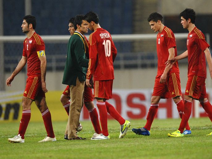 Syria's Portuguese coach rui Miguel Garcia Lopes (2nd L) comforts his players following their loss in the London Olympics Asian Qualifiers Play-off football match between Syria and Uzbekistan in Hanoi on March 27, 2012. Uzbekistan won 2-1. AFP PHOTO /HOANG DINH Nam