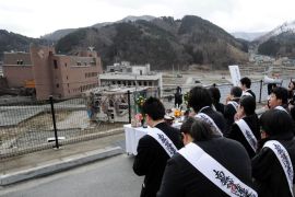People pray for the victims of the March 11, 2011 tsunami as part of the first year anniversary of the disaster in Onagawa, Miyagi prefecture, on March 11, 2012. Public life in Japan was to pause as the nation marked a year since a huge earthquake and tsunami killed 19,000